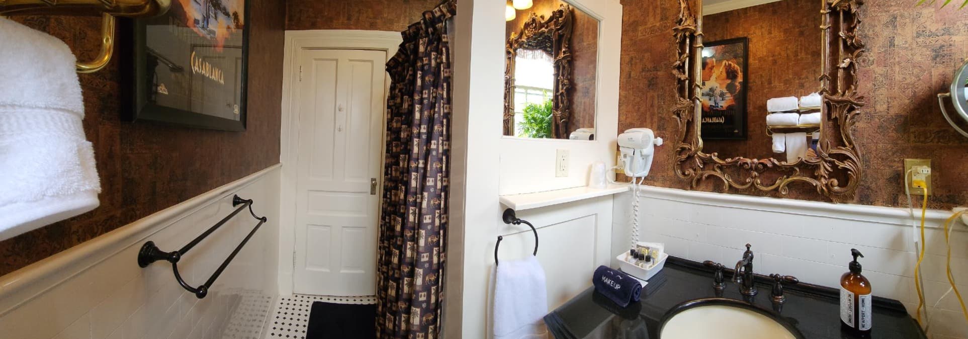 Panoramic view of a brightly lit bathroom featuring a shower, sink, and decorative elements.